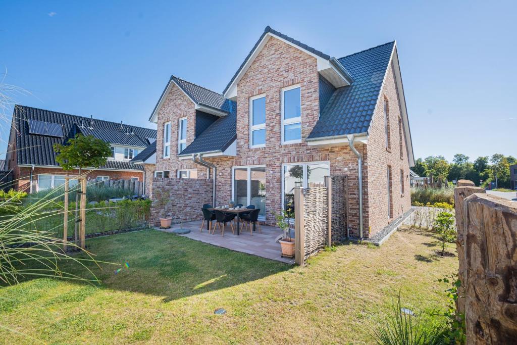 a large brick house with a patio with a table at 36 Grad in Garding