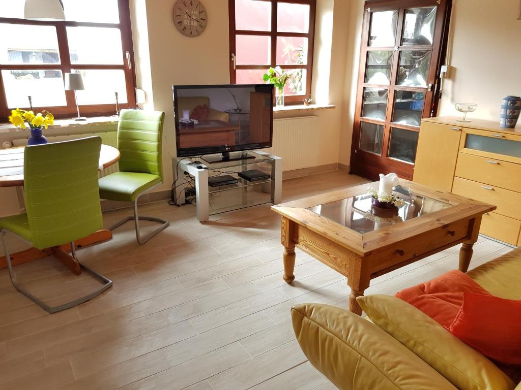 a living room with a couch and a table and a tv at Backboord in Poppenbüll