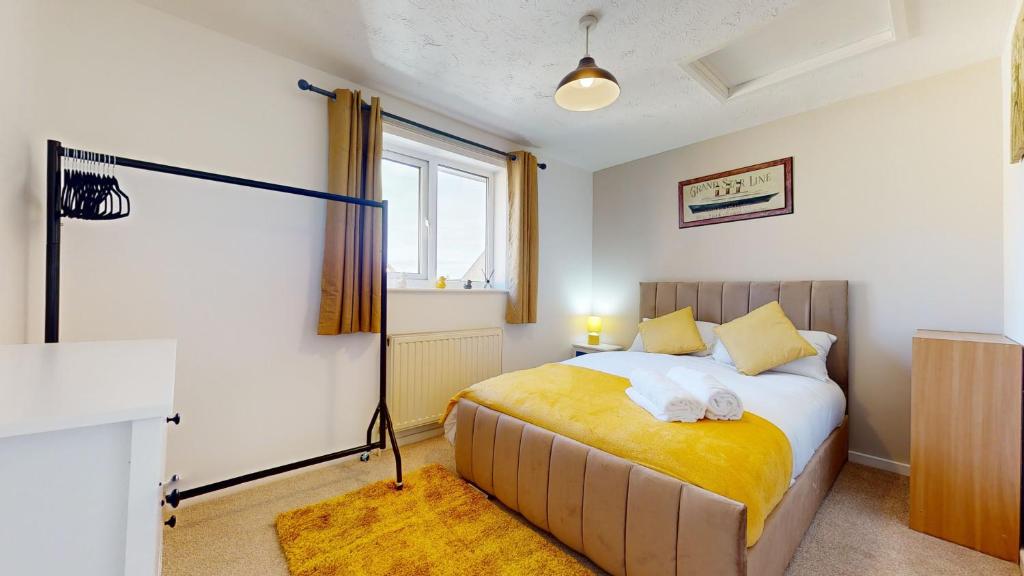 a bedroom with a bed with a yellow blanket at Cosy 2 double bed property in Milton in Milton