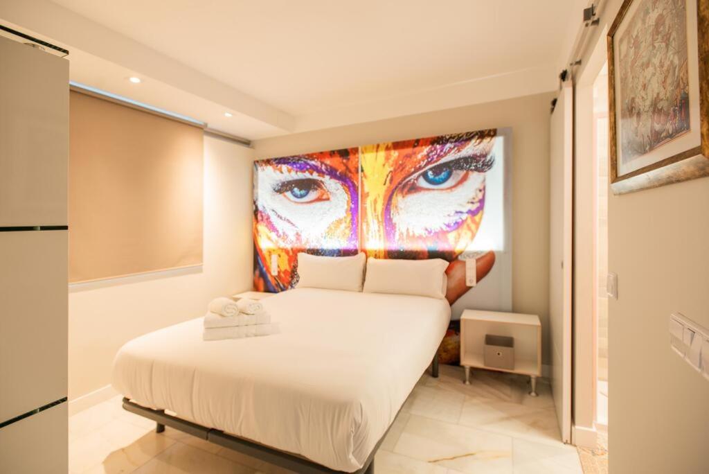 sypialnia z łóżkiem z dużym obrazem na ścianie w obiekcie Homelikes Madrid w Madrycie