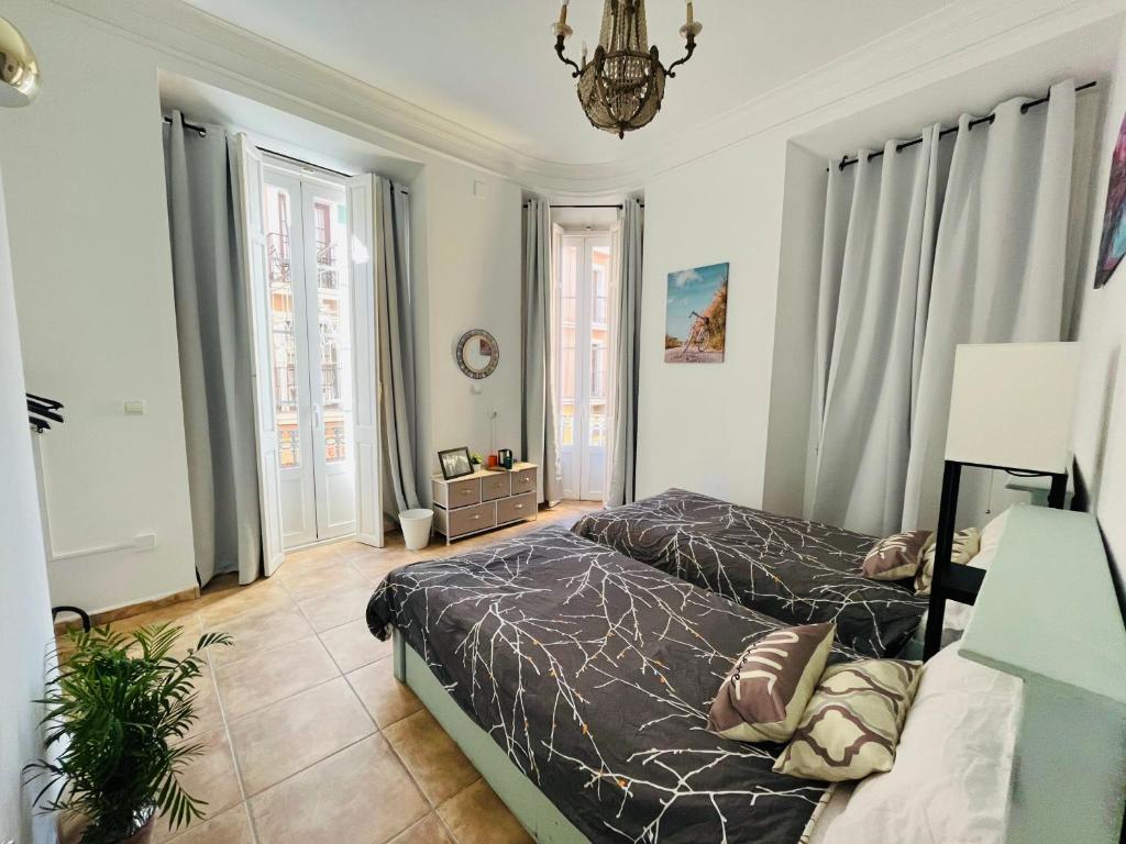 um quarto com 2 camas e um lustre em Malak-Rooms em Málaga