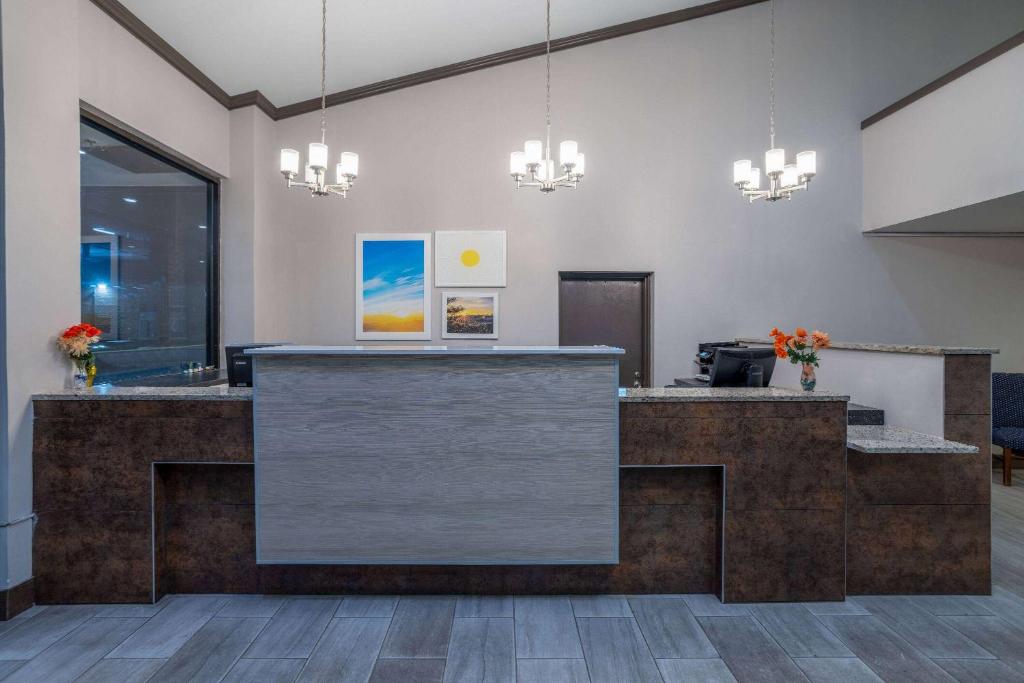 an office lobby with a reception desk and chandeliers at Days Inn by Wyndham Manassas Battlefield in Manassas