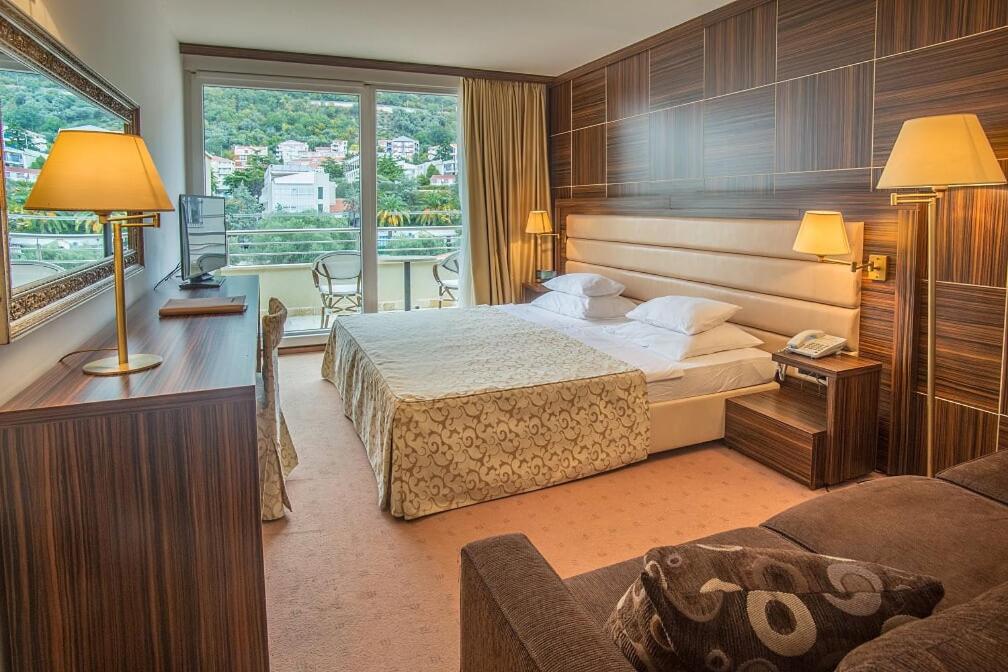 a hotel room with a bed and a balcony at Hotel Palas in Petrovac na Moru