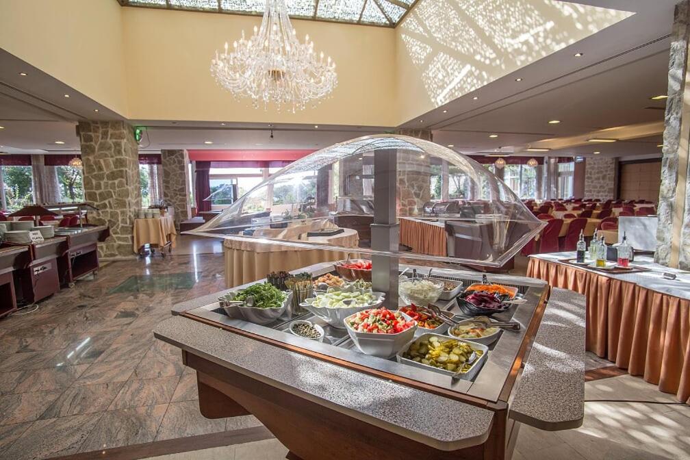 a buffet in a restaurant with food on a table at Hotel Palas in Petrovac na Moru