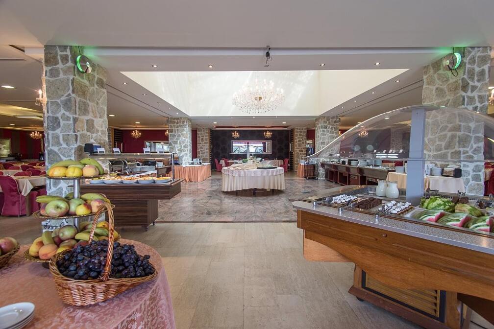 a restaurant with a buffet line with fruits and vegetables at Hotel Palas in Petrovac na Moru