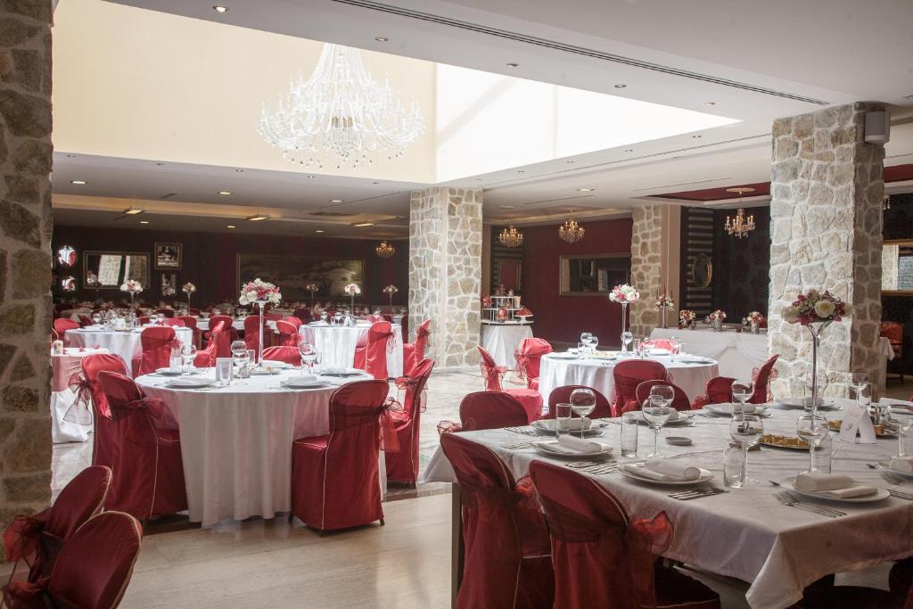 a dining room with white tables and red chairs at Hotel Palas in Petrovac na Moru