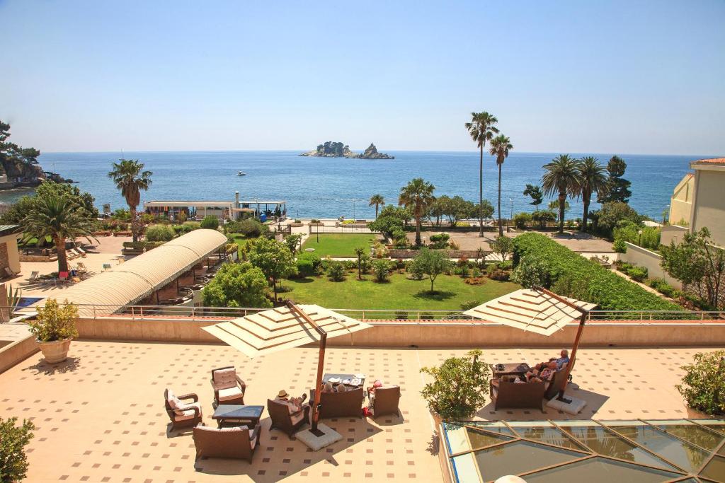 a view of a park with chairs and the ocean at Hotel Palas in Petrovac na Moru