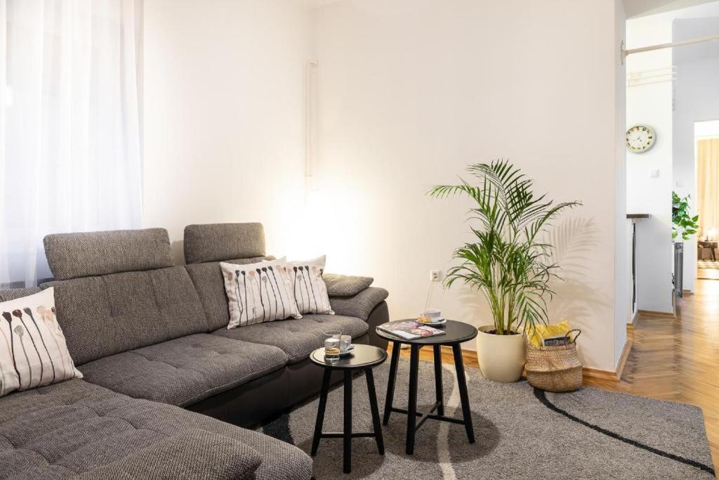 uma sala de estar com um sofá e duas mesas em Lea and Maks's City Apartment URBAN STAY em Zagreb