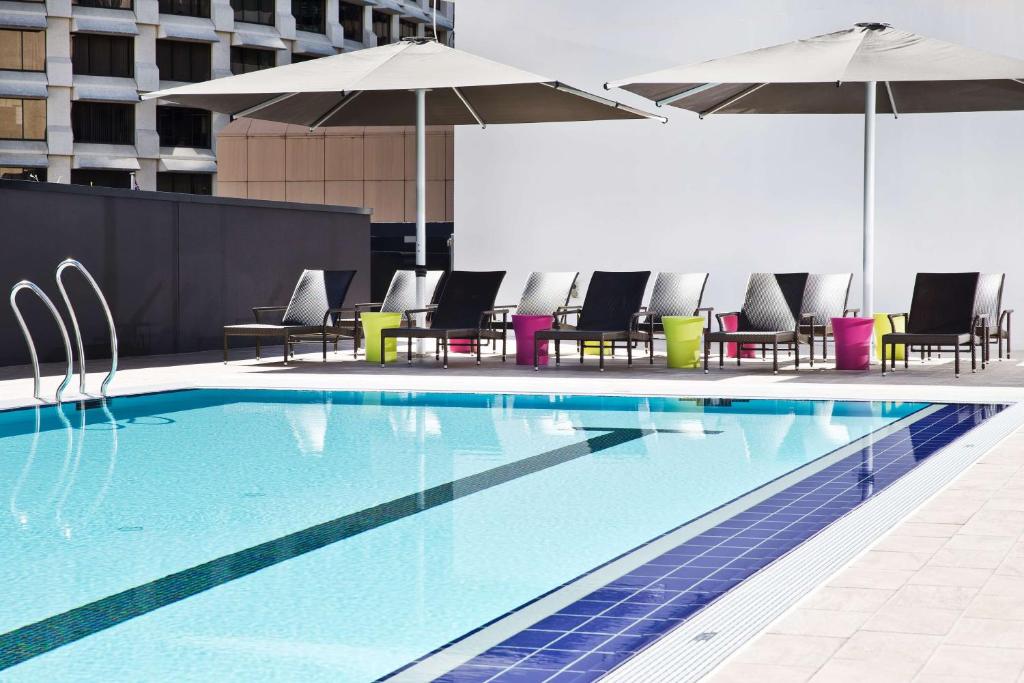a large swimming pool with chairs and umbrellas at Hilton Brisbane in Brisbane