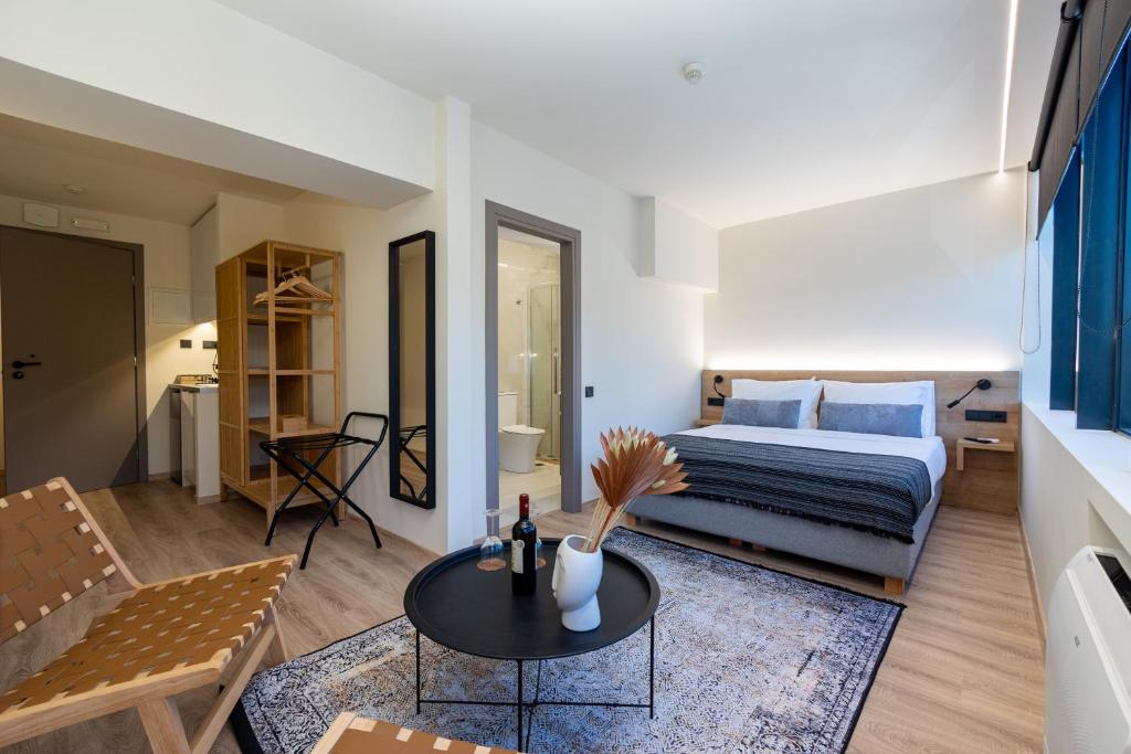 1 dormitorio con 1 cama y 1 mesa en una habitación en Athens Airport Living spaces en Spáta