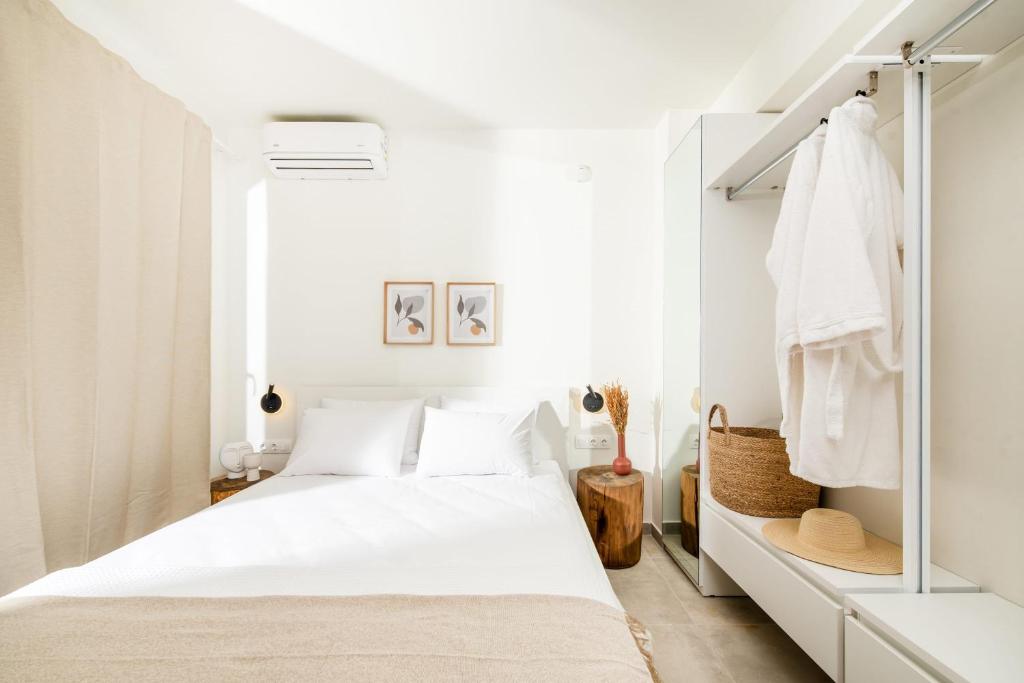 Dormitorio blanco con cama y armario en serene villas halkidiki - Cfront private pool en Epanomi