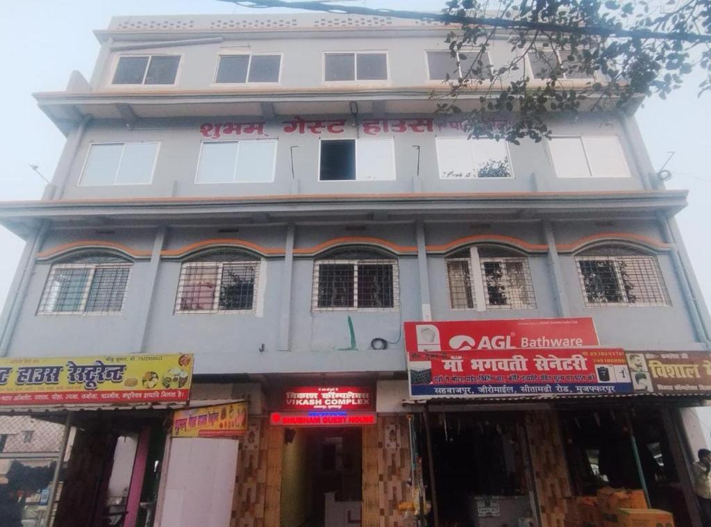 un edificio bianco con dei cartelli di fronte di Shubham guest house a Muzaffarpur