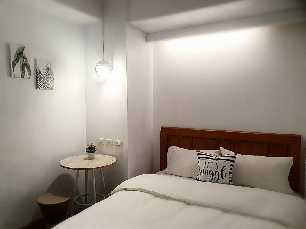 a small bedroom with a bed and a table at COZY Home in Taipei