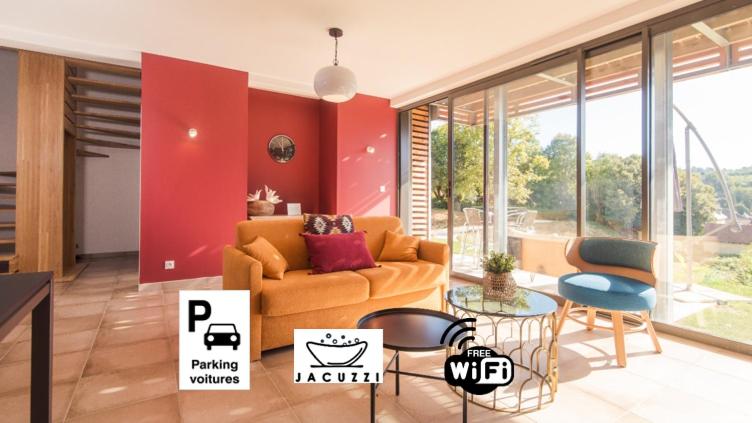 ein Wohnzimmer mit einem Sofa, einem Tisch und Stühlen in der Unterkunft 100% Relax avec Jacuzzi Privatif in Sarlat-la-Canéda