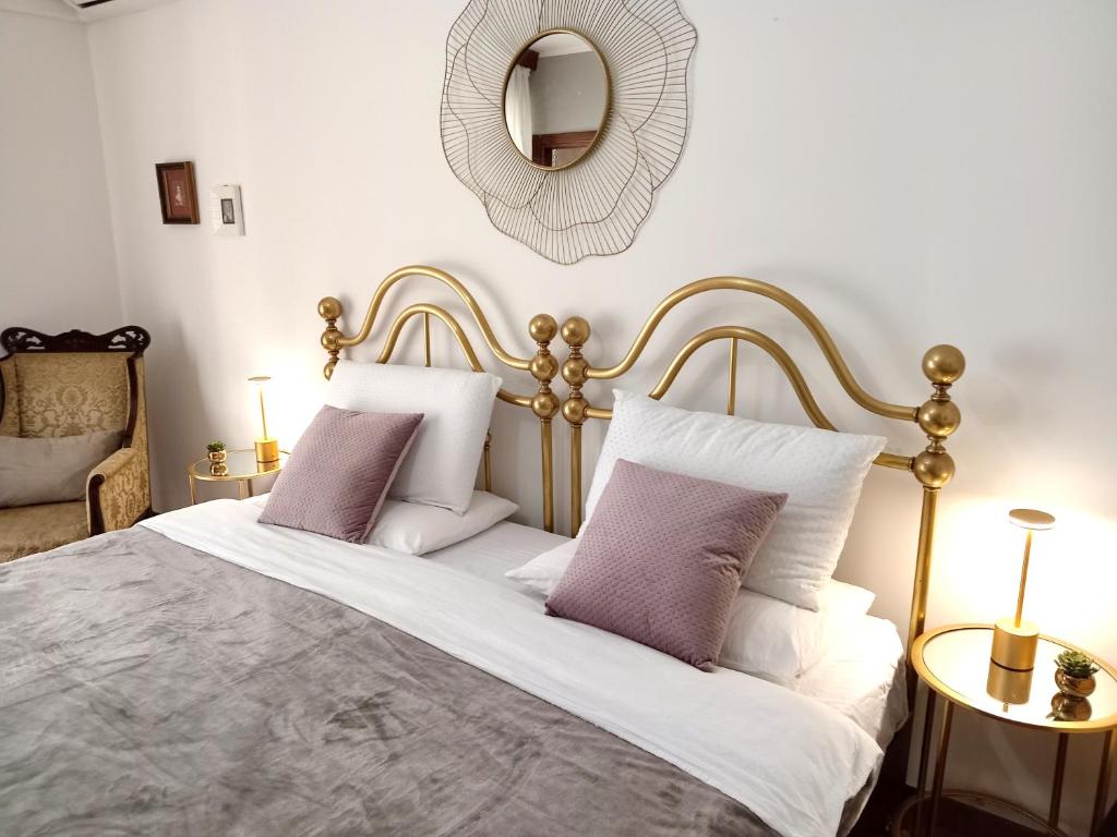 a bedroom with a bed with purple pillows and a mirror at Le Tre Civette in Sassari
