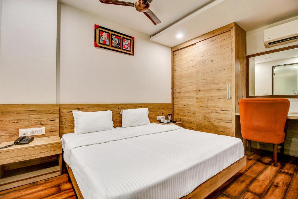 a bedroom with a bed and a desk with a chair at FabHotel Manjeet in Bhopal