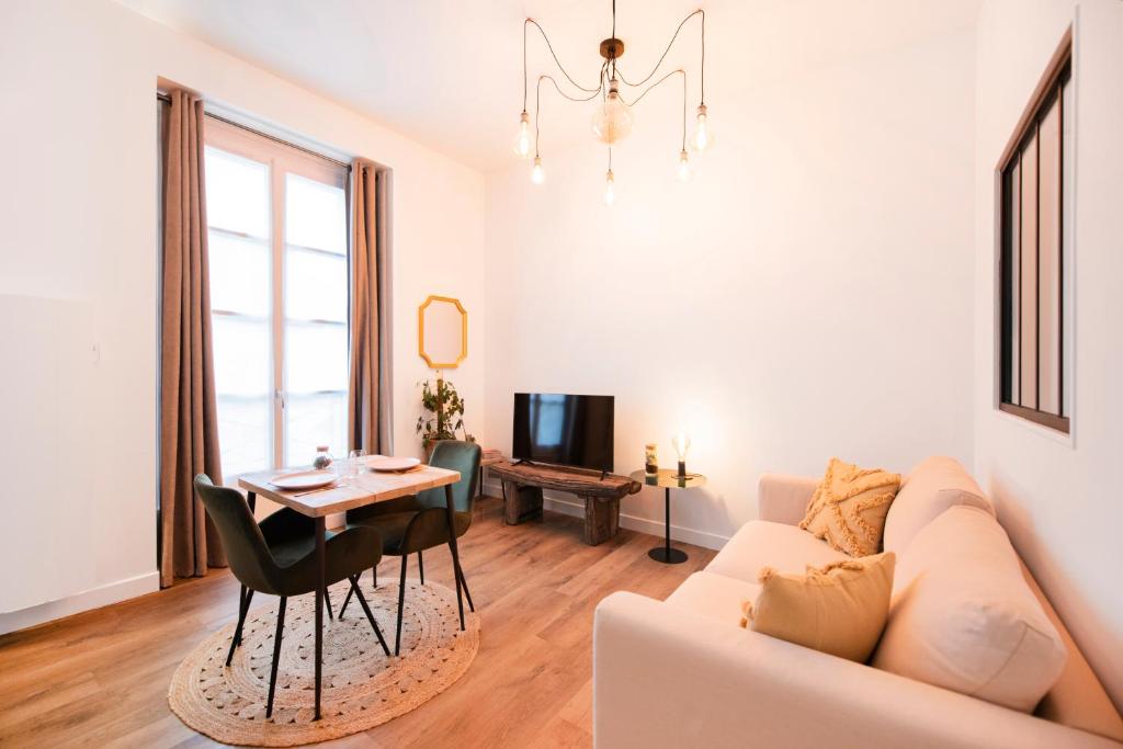 una sala de estar con un sofá y una mesa en Le Laurencin Sens - Le Campagne - Cœur de ville, en Sens