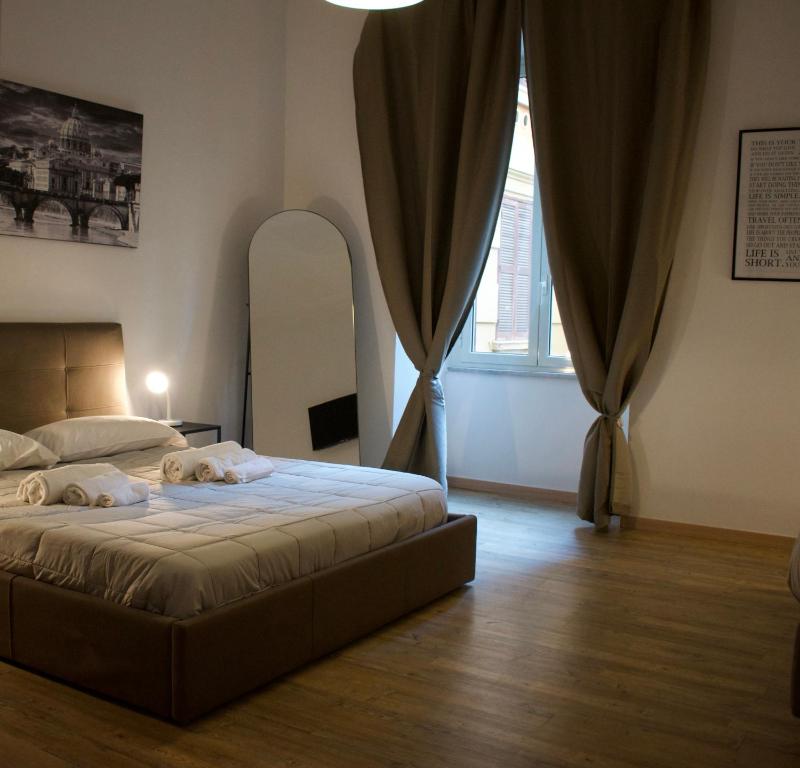 a bedroom with a bed and a large window at Lavinia Apartment In Trastevere in Rome