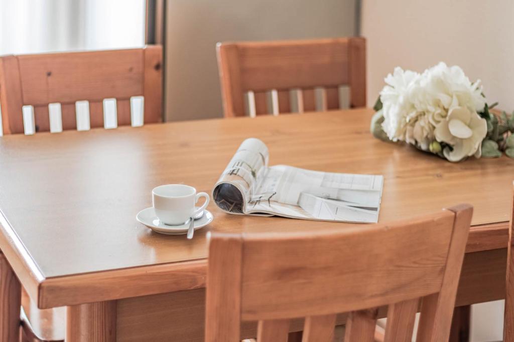una mesa con un periódico y una taza de café. en Il lago di Diana, en Mandello del Lario