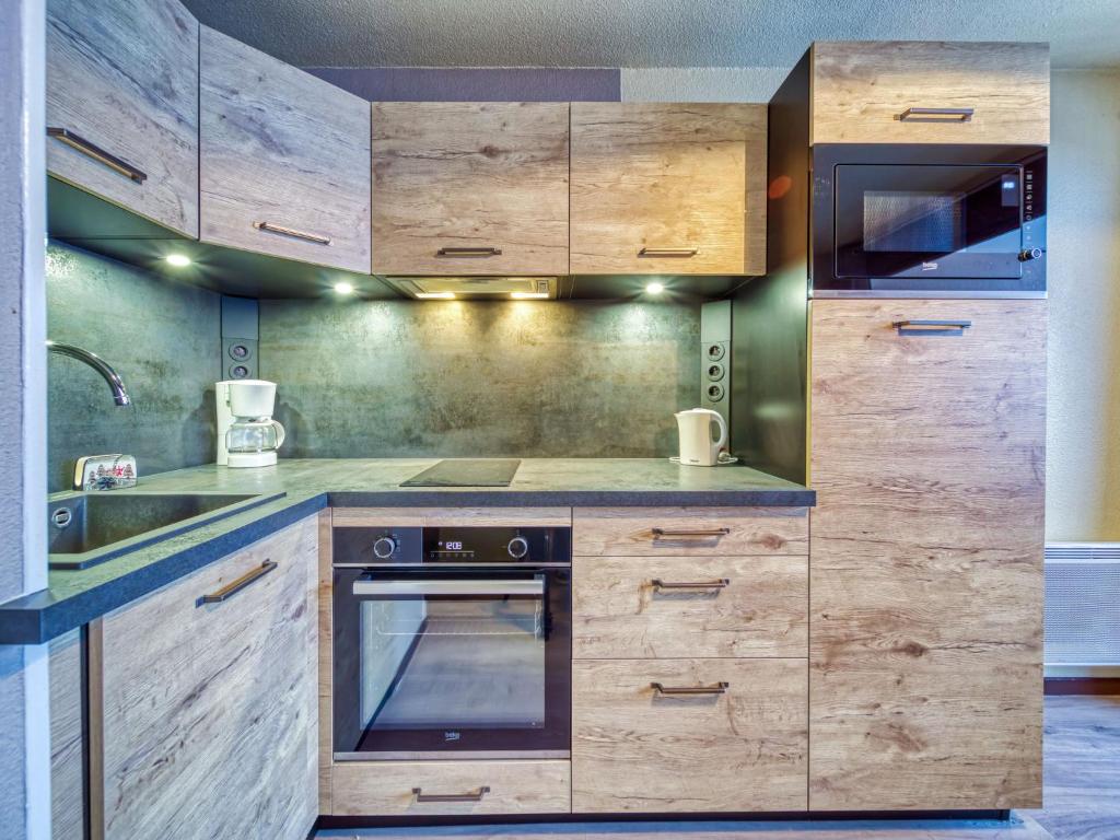 une cuisine avec des armoires en bois et un évier dans l'établissement Apartment Argousier 134 B by Interhome, aux Menuires