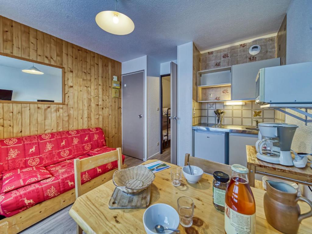 un salon avec un canapé rouge et une table dans l'établissement Apartment Argousier 45 A by Interhome, aux Menuires