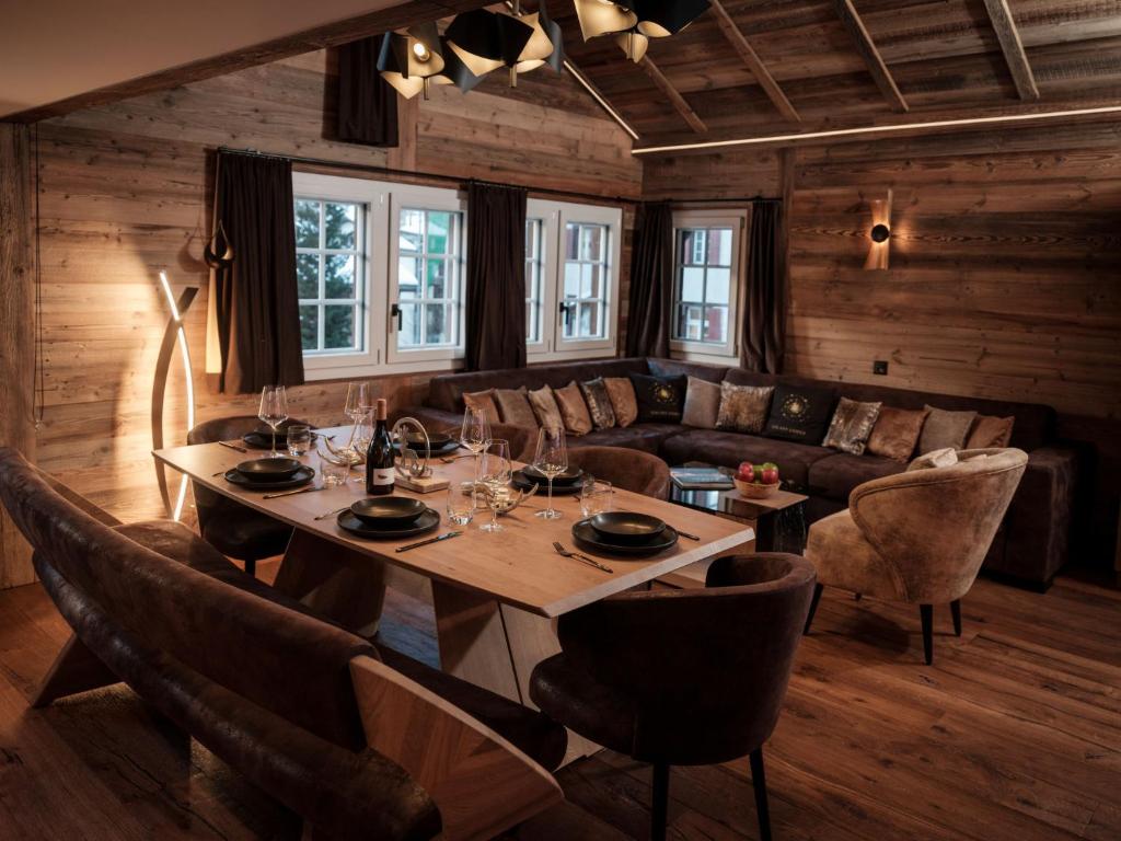 ein Esszimmer mit einem Tisch und einem Sofa in der Unterkunft Apartment Kirchplatz by Interhome in Zermatt