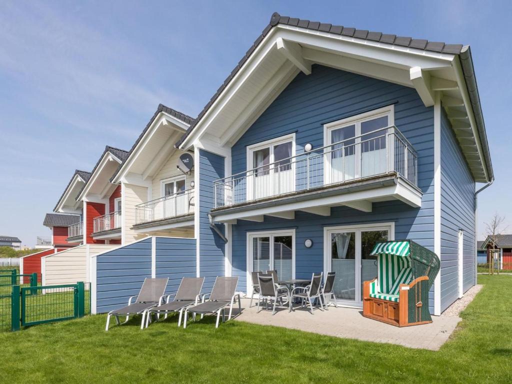 a blue house with chairs in front of it at Holiday Home Trottellumme by Interhome in Dagebüll