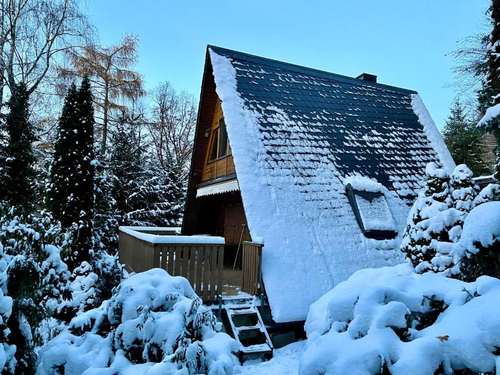 a house covered in snow with trees and bushes at Holiday Home Gräfenroda by Interhome in Dörrberg