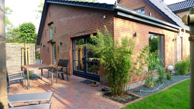 a brick house with a patio with a table and chairs at Carlotta Studio in Osterhever