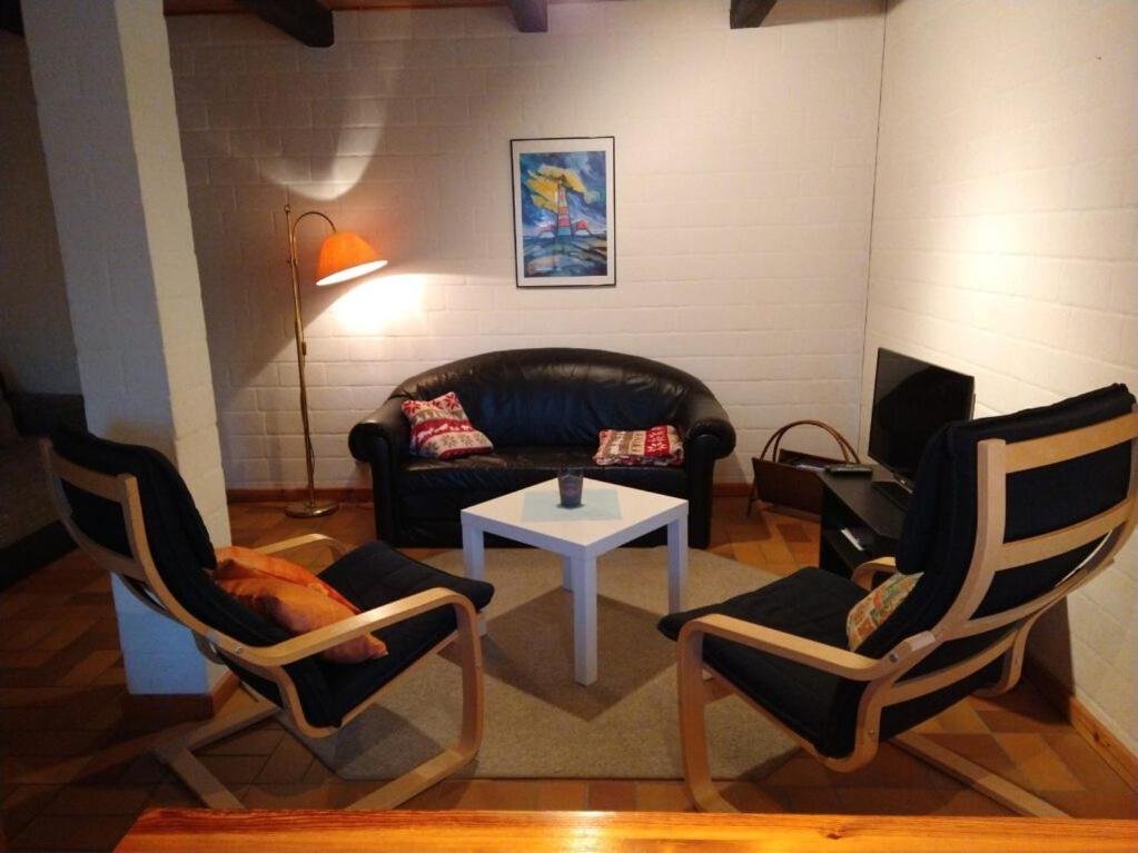 a living room with two chairs and a couch and a table at FW auf dem Land in Garding