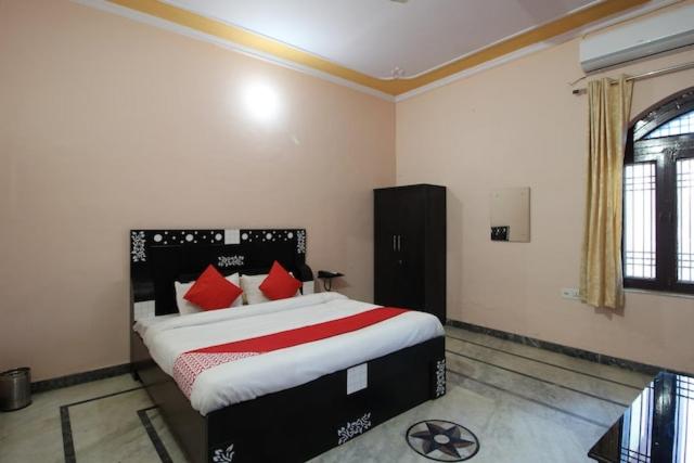 ein Schlafzimmer mit einem großen Bett mit roten Kissen in der Unterkunft Hotel Pink Haveli in Jaipur