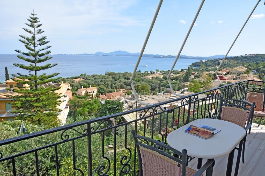 een balkon met een tafel en uitzicht op het water bij Butterfly Barbati apartments in Barbati