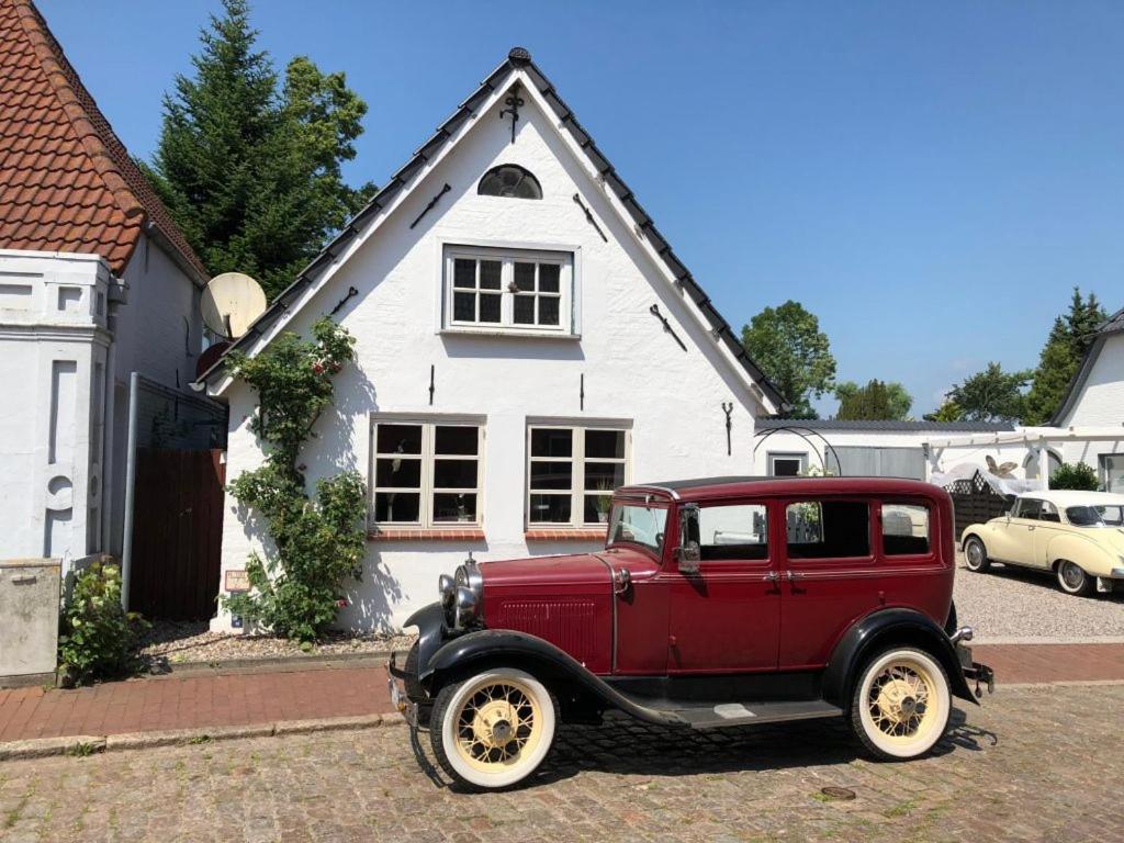 a red truck parked in front of a white house at Landhaus Everschop in Tetenbüll