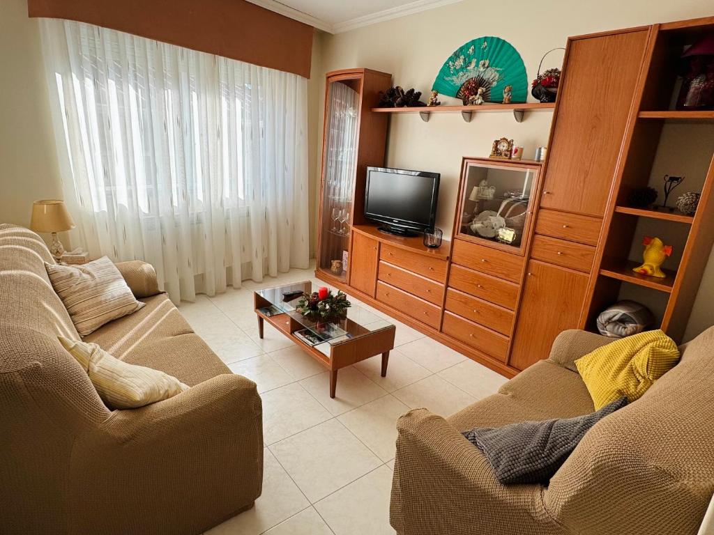 a living room with two couches and a tv at CASA GLORIA in Combarro