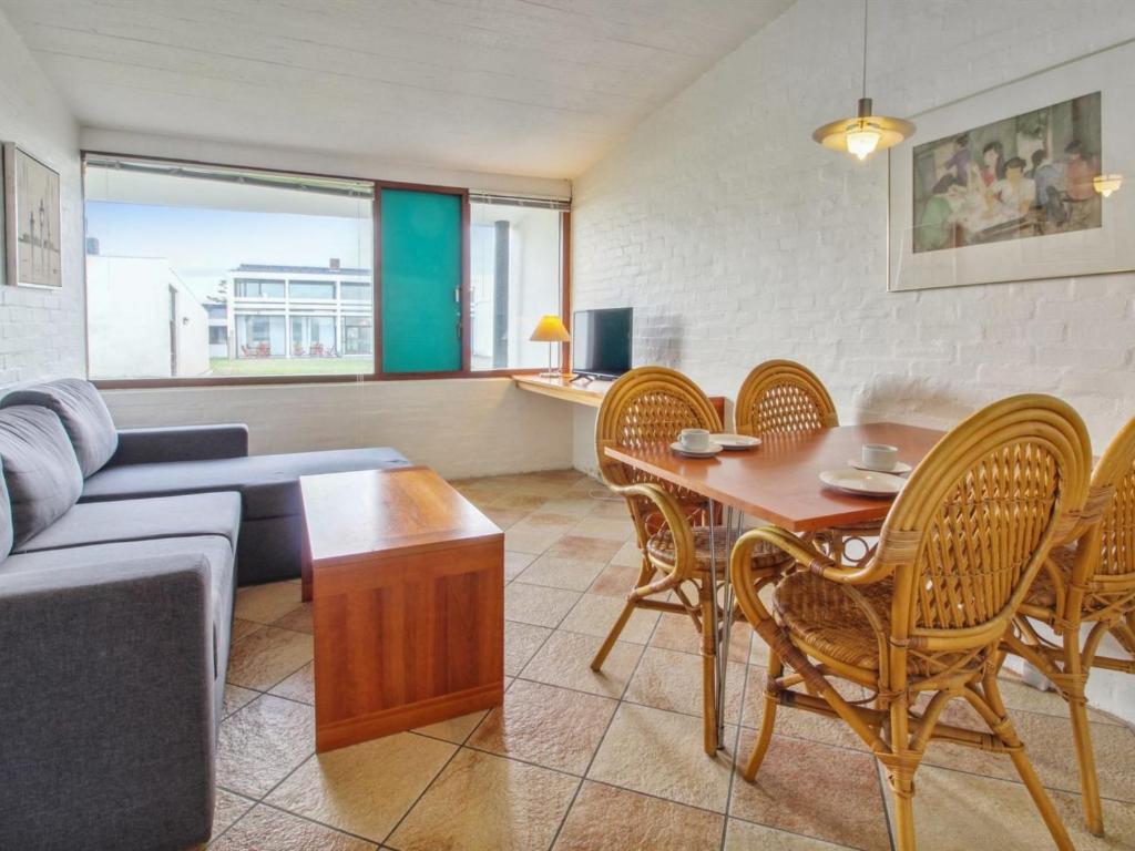 sala de estar con sofá, mesa y sillas en Apartment Gunnlaug - 500m from the sea in Western Jutland by Interhome, en Lakolk