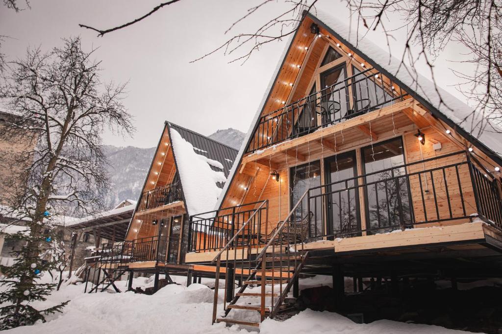 a log cabin in the snow with a staircase at M&L in Mestia