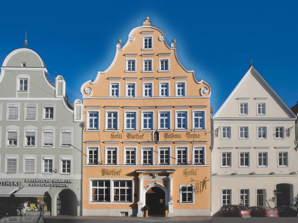 ein großes Gebäude in der Mitte von zwei anderen Gebäuden in der Unterkunft Hotel Goldene Sonne in Landshut