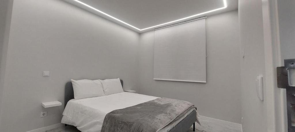 um quarto com uma cama num quarto branco em Seven no Funchal