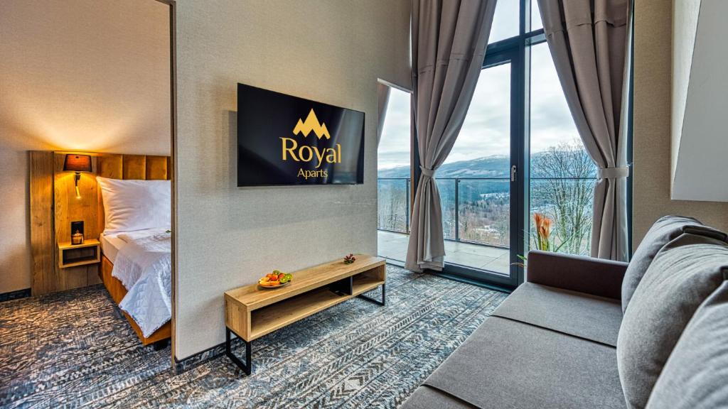 a hotel room with a bed and a large window at Apartamenty z basenem ROYAL APARTS Złoty Horyzont VIP, SPA i restauracja in Szklarska Poręba