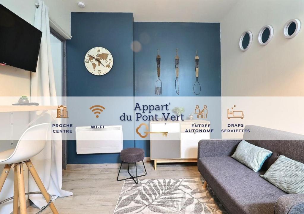 salon z kanapą i zegarem na ścianie w obiekcie Appart du Pont Vert A02 proche centre Mon Groom w Troyes