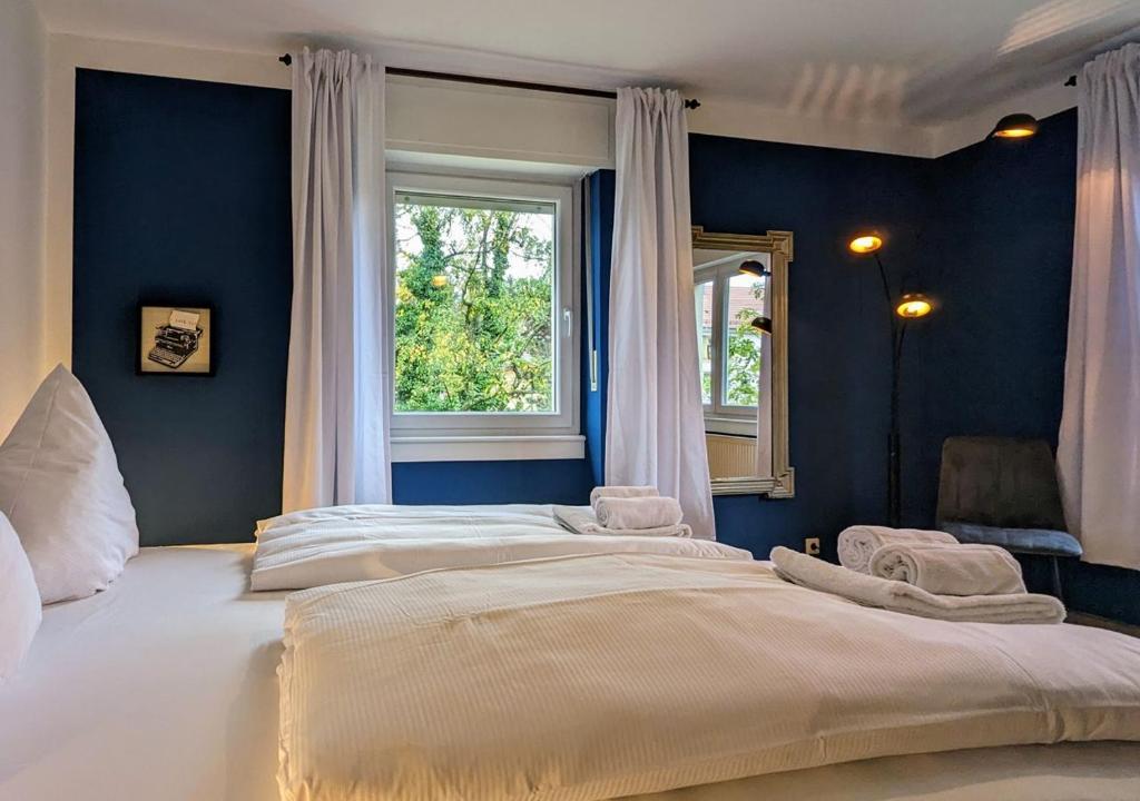 uma cama grande num quarto azul com uma janela em 65qm Altbaucharme mit zwei Balkonen em Karlsruhe