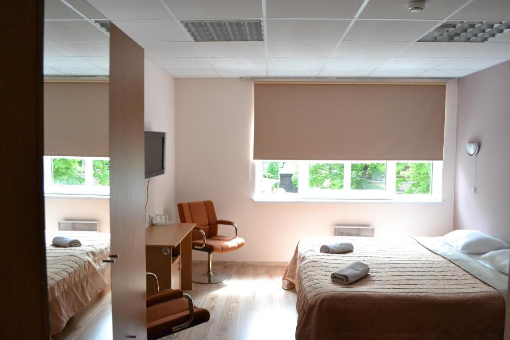 - une chambre avec 2 lits, un bureau et 2 fenêtres dans l'établissement Villa Katariina, à Pärnu