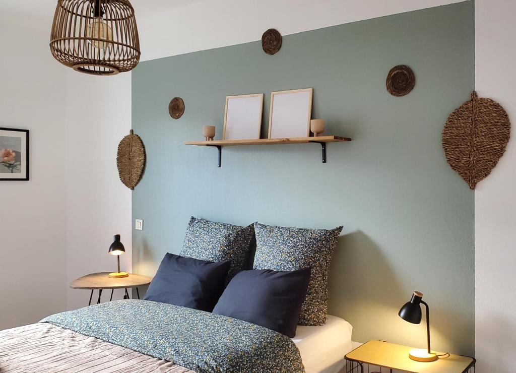 a bedroom with blue walls and a bed with blue pillows at Le Canal Wi-Fi Parking Jardin Piscine 15 mn de Béziers in Colombiers