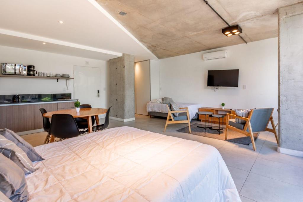 a bedroom with a large bed and a table at NUEVO Loft triple a 5 minutos de Puerto Madero 1A in Buenos Aires