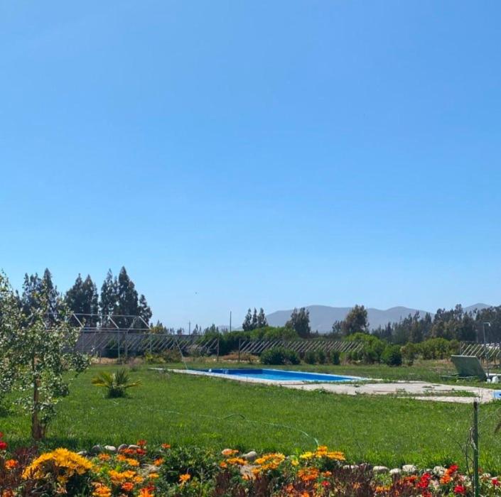 um jardim com piscina e flores em Fogones del Valle em La Serena