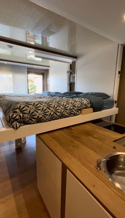 a bed on a platform in a tiny house at Studio cosy et moderne aux pieds des pistes in LʼHuez
