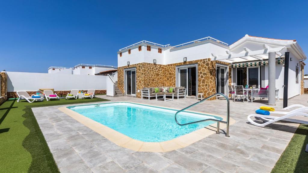 uma villa com piscina em frente a uma casa em CASA LOTTIE em La Guirra