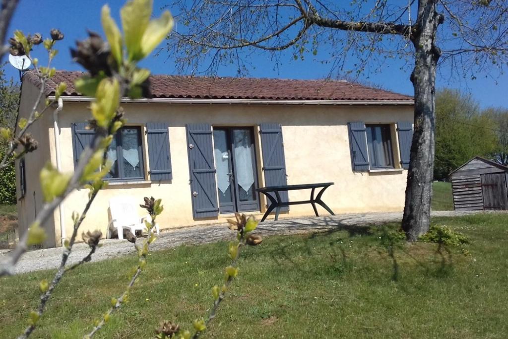 una pequeña casa con un banco delante en Le Tilleul en périogord Noir proche Sarlat, en Paulin