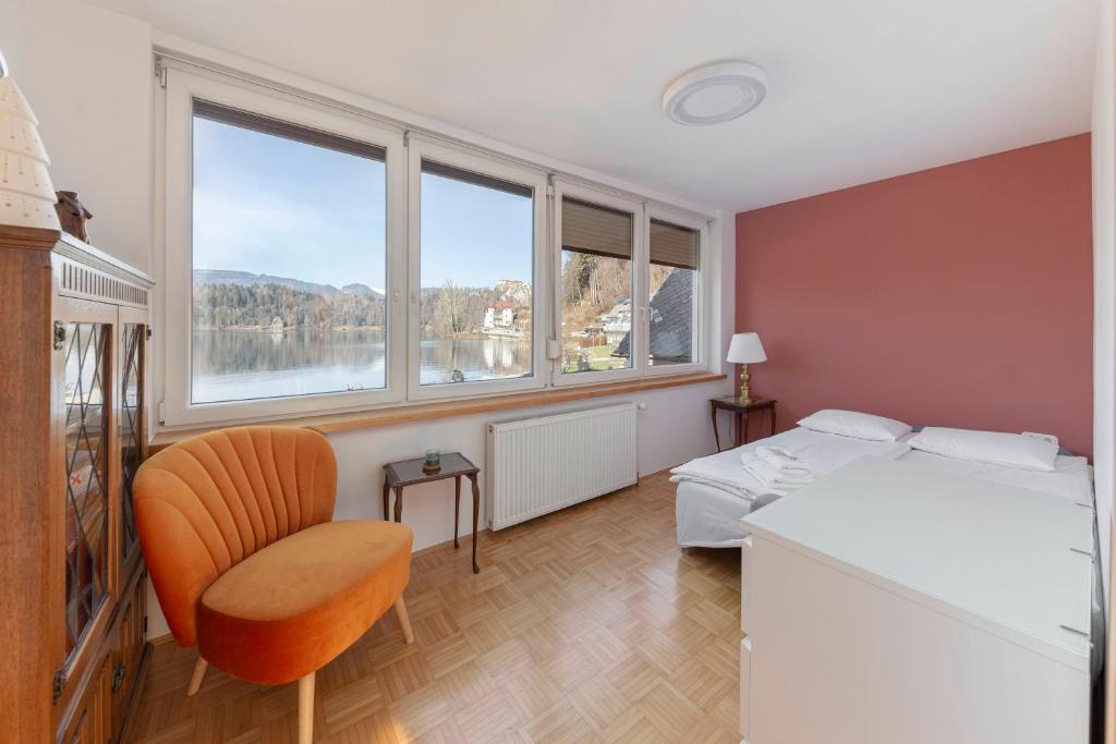 1 dormitorio con 1 cama, 1 silla y ventanas en Lakeview Bled Heaven Apartments, en Bled