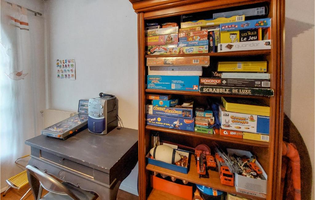 a book shelf filled with books next to a table at Beautiful Home In Angresse With Wi-fi in Angresse